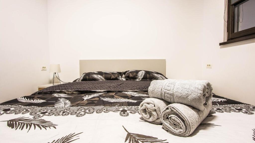 a bedroom with a bed with towels on it at Complex panoramic Mihai Bravu cu internet de mare viteza si parcare gratuita in Bucharest