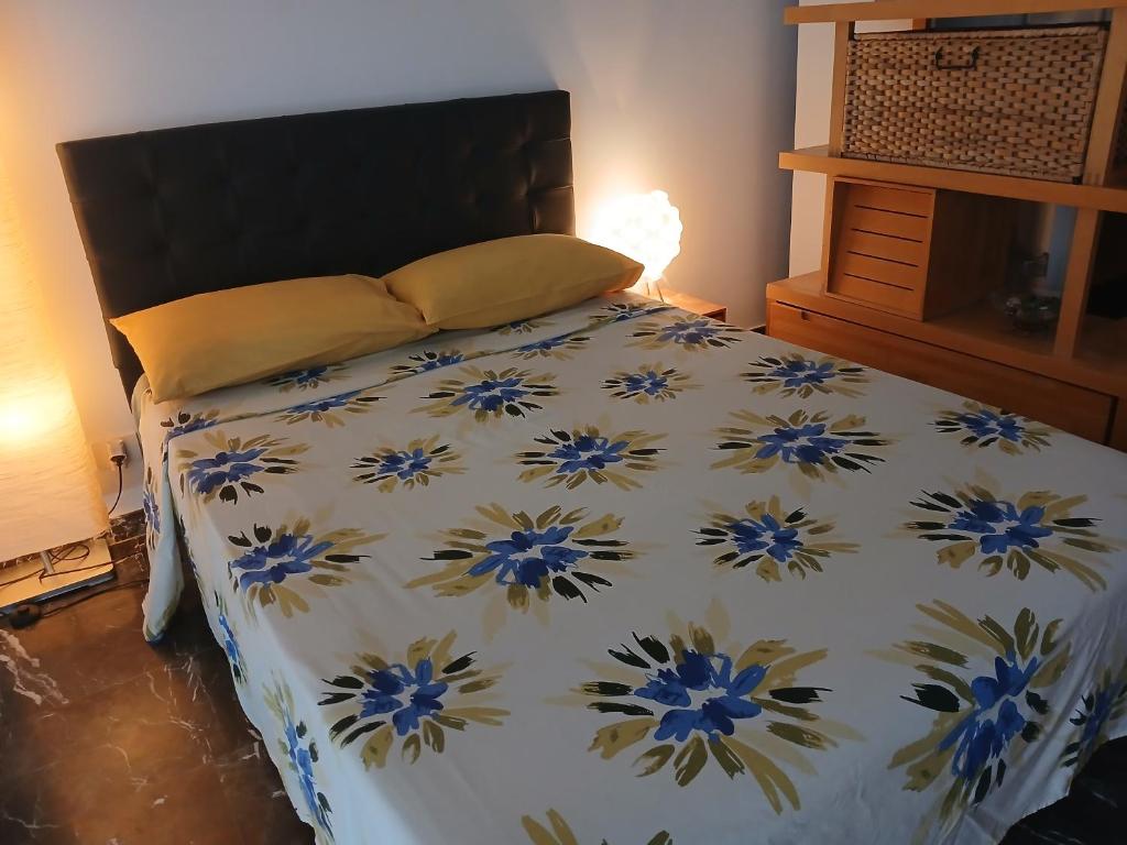 a bedroom with a bed with a blue and white comforter at Buenavista in Acantilado de los Gigantes