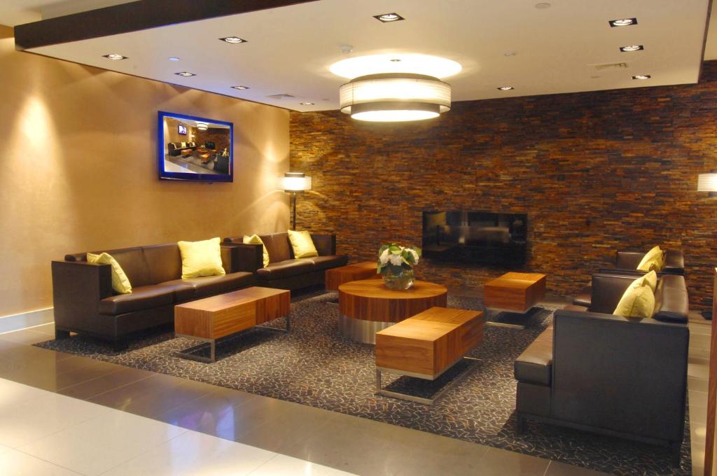 a lobby with couches and a tv and a fireplace at Stamford Bridge Hotel London in London