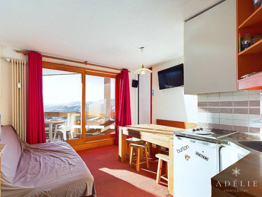een keuken met een tafel en een keuken met uitzicht bij Charmant 2P avec Parking, Balcon, près des Pistes et Commerces à Montvalezan - FR-1-398-509 in La Rosière