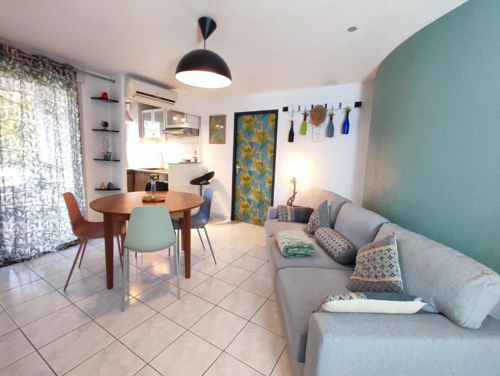 un salon avec un canapé et une table dans l'établissement Roseraie T2 Wifi Parking Clim, à Toulouse