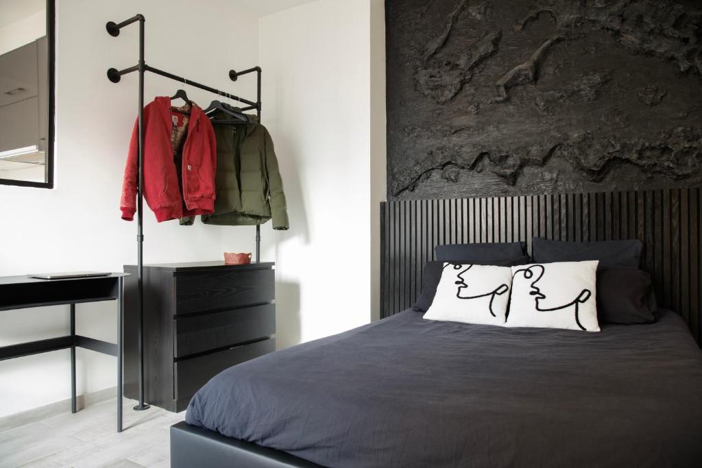 une chambre avec un lit et une commode dans l'établissement L'Atelier Contemporain - Porte de Paris, Stade de France, Aéroport CDG, à Aubervilliers