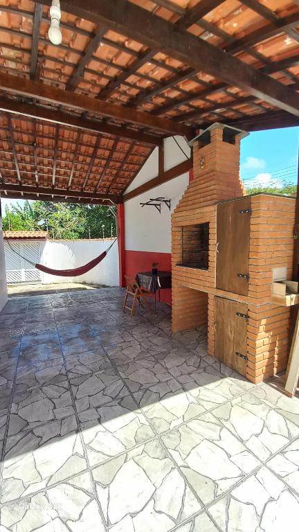 an outdoor patio with a brick oven in a building at Oásis Flórida in Peruíbe