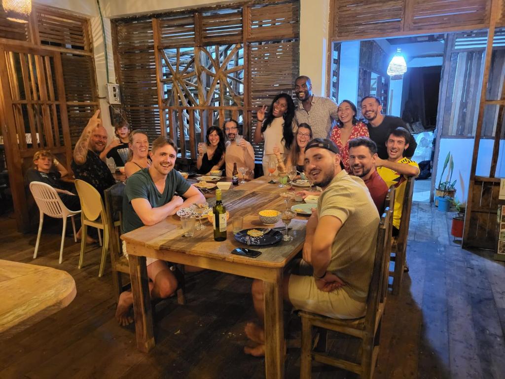 a group of people sitting around a wooden table at Utria hostel in El Valle