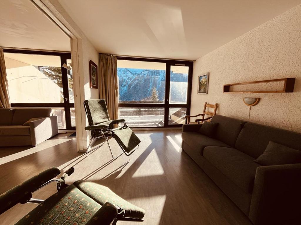 un salon avec un canapé et une grande fenêtre dans l'établissement Spacieux appart 2 pièces pour 9 personnes avec terrasse à Plan Peisey - FR-1-757-104, à Peisey-Nancroix