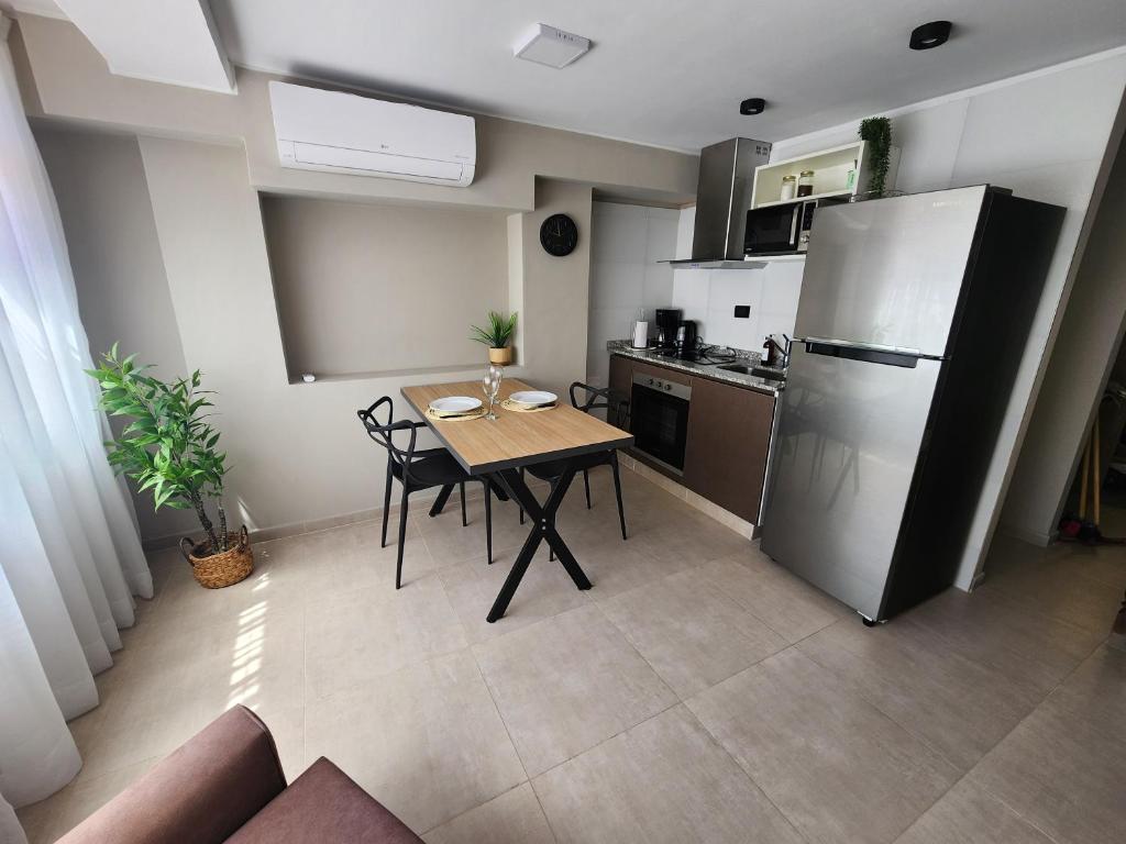 eine kleine Küche mit Tisch und Kühlschrank in der Unterkunft Emilio Jofré II - Departamento céntrico y luminoso in Villa Marini