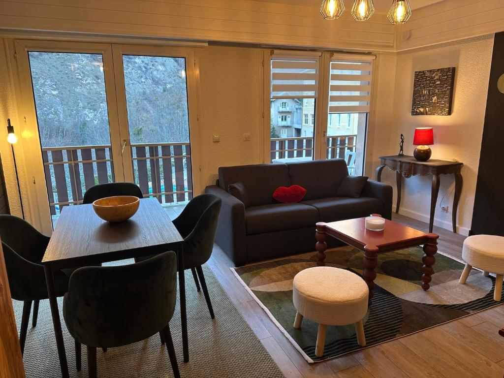a living room with a couch and a table and chairs at Loft HATISAS in Brides-les-Bains