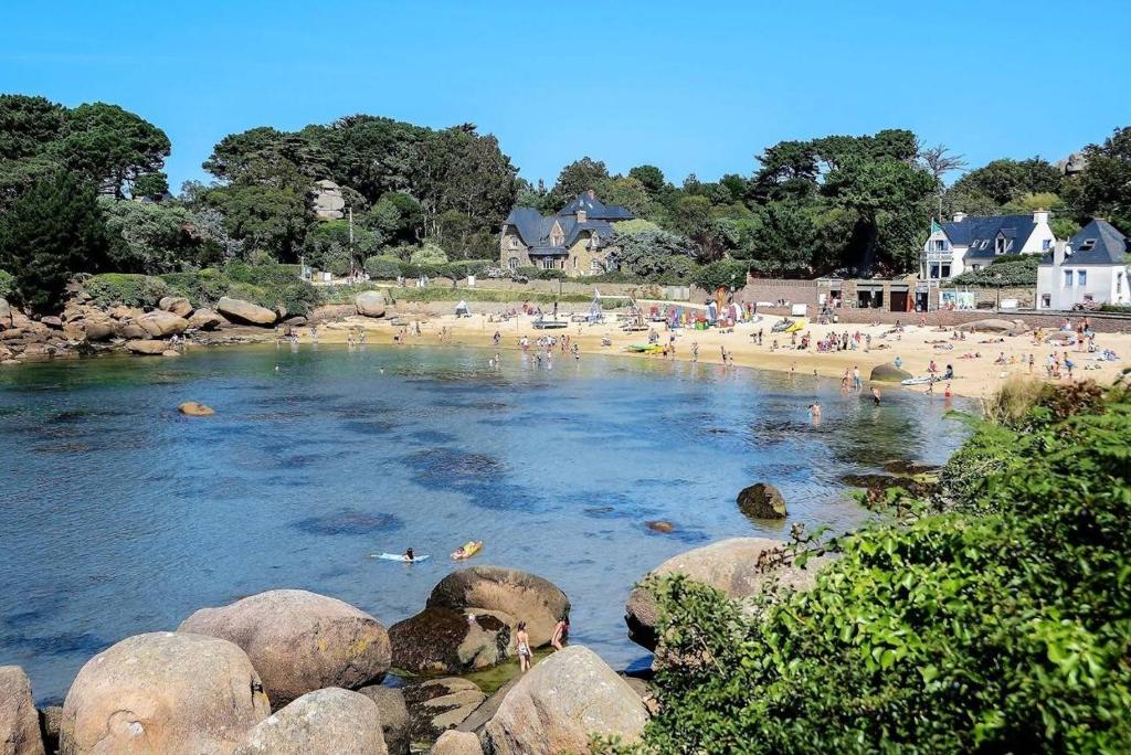 un groupe de personnes nageant dans l'eau sur une plage dans l'établissement Appartement avec terrasse à 100m plage St-Guirec à PLOUMANAC'H - Réf 896, à Perros-Guirec