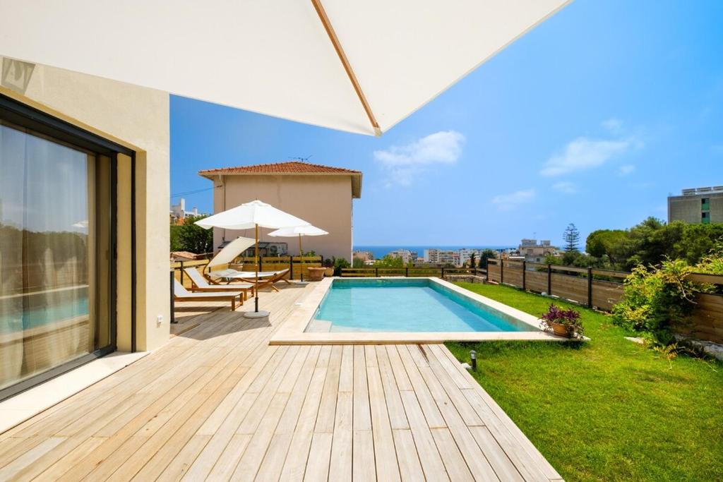 une arrière-cour avec une piscine et une terrasse dans l'établissement Villa moderne pour 8 personnes - Vue sur Nice !, à Nice