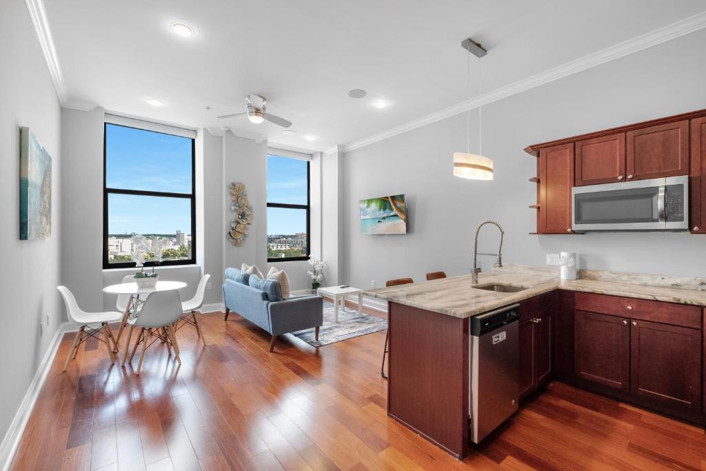 een keuken en woonkamer met een tafel en stoelen bij Modern 1BR with Rooftop Pool & Gym in Philadelphia