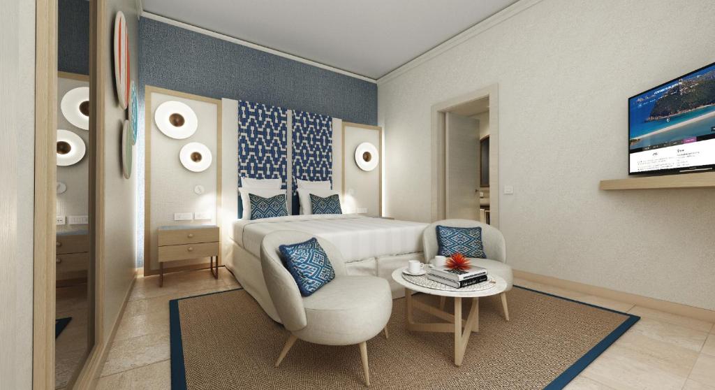 a bedroom with a bed and a chair and a tv at Almar Timi Ama Resort & Spa in Villasimius