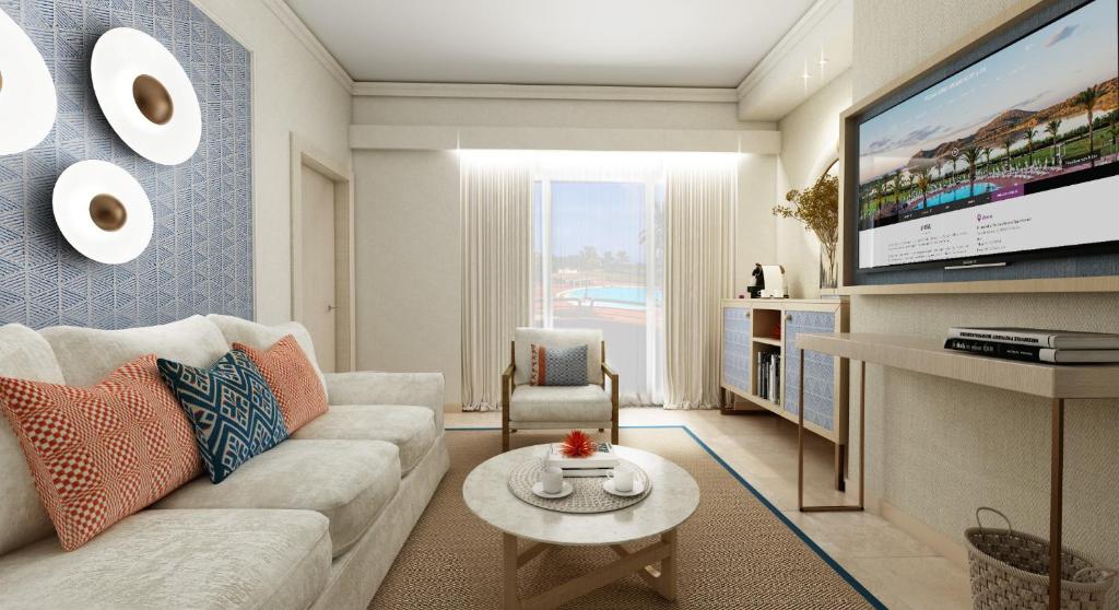a living room with a couch and a tv at Almar Timi Ama Resort & Spa in Villasimius