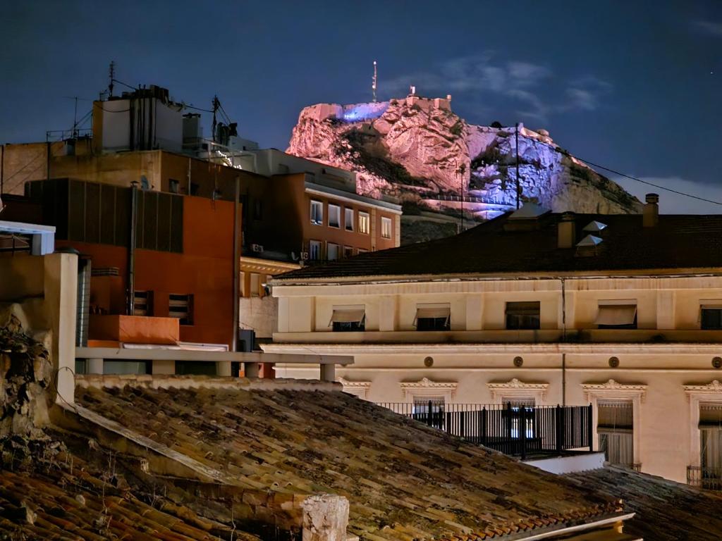 a mountain in the background with a city and buildings at Apartamentos Plaza,viviendas turisticas in Alicante