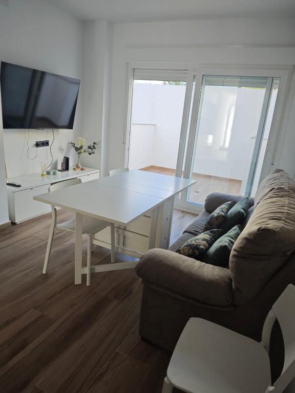 a living room with a white table and a couch at Apartamento de dos habitaciones in Barbate
