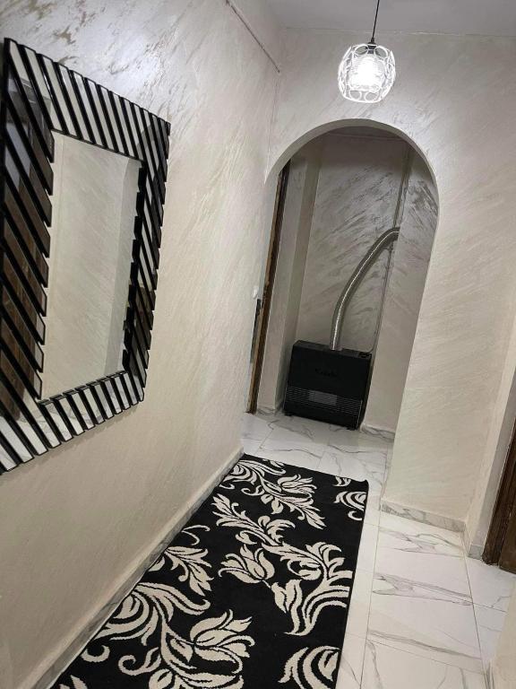 a hallway with a black and white carpet and a mirror at ApartementF3 in Constantine