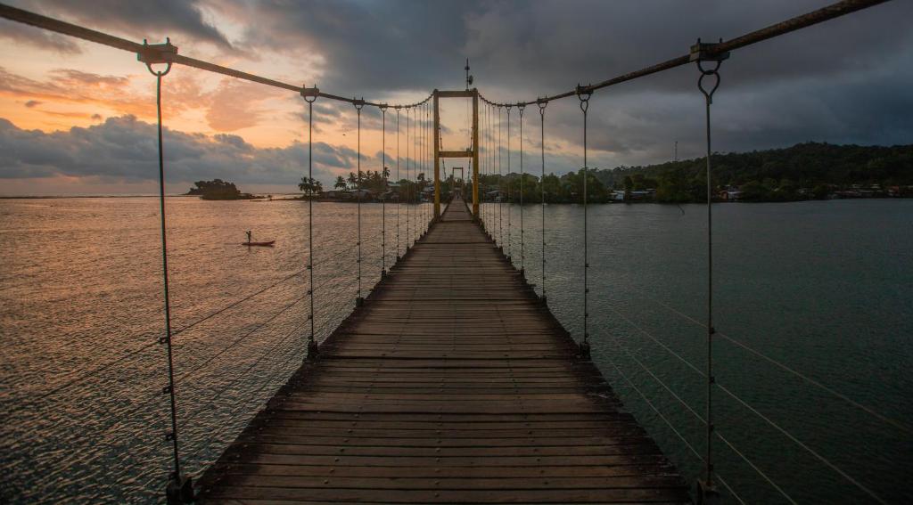 a suspension bridge over a body of water at Utria hostel in El Valle