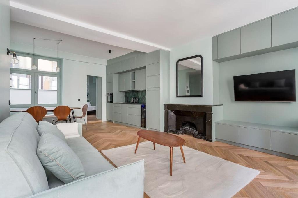 een woonkamer met een bank en een open haard bij Suite St Antoine 4 travelers in Lyon