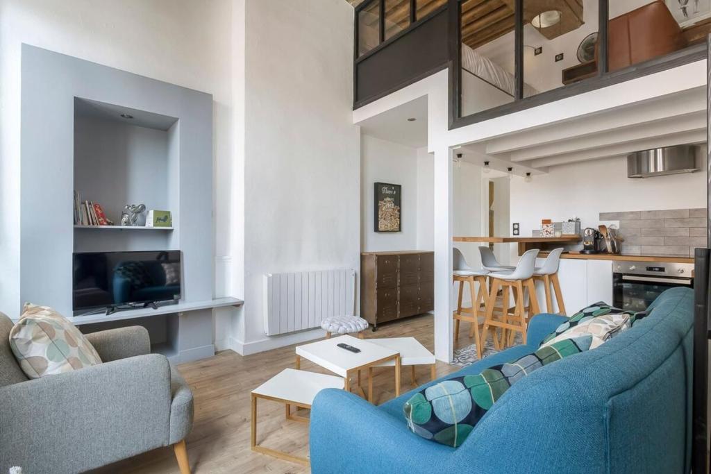 un salon avec deux chaises bleues et une table dans l'établissement Burdeau 1st Arrondissement, à Lyon