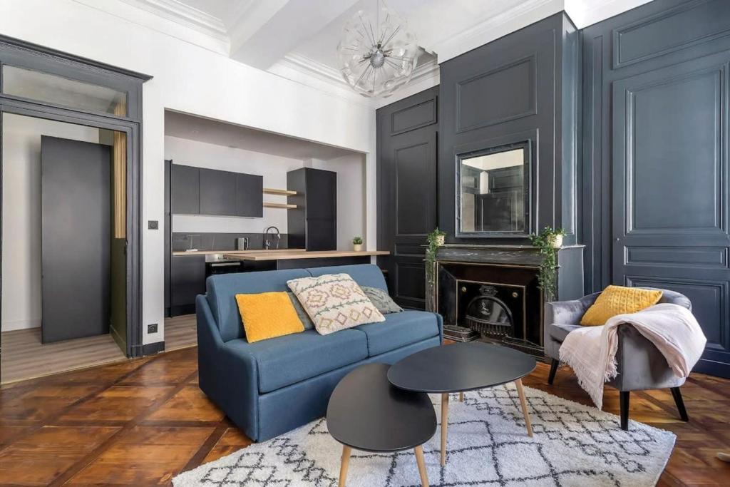 un salon avec un canapé bleu et une cheminée dans l'établissement Le Méritant Jacobins Center of Lyon, à Lyon