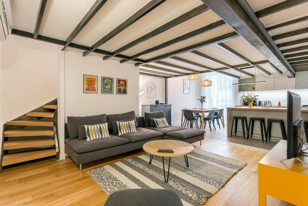 un salon avec un canapé et une table dans l'établissement Hamac Suites - Suite Herbouville - Quai du Rhône, à Lyon