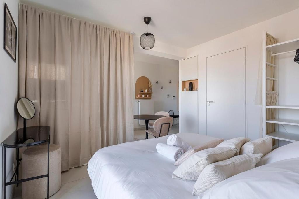 - une chambre blanche avec 2 lits et une table dans l'établissement Le 13ème étage - Lafayette Lyon 3, à Lyon