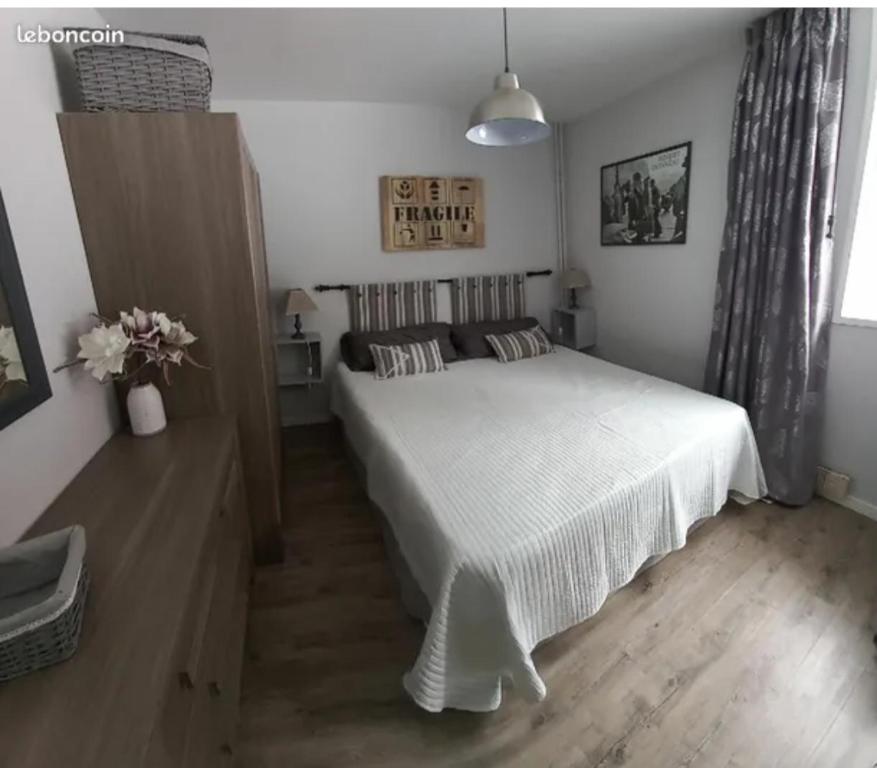 une chambre avec un lit blanc dans une pièce dans l'établissement L'Accolade, à Le Mont-Dore