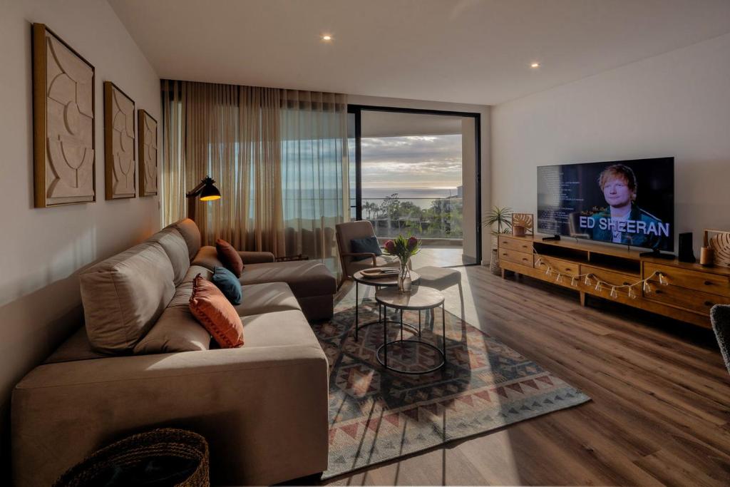 ein Wohnzimmer mit Sofa und Fernseher in der Unterkunft Peace Haven III in Câmara de Lobos