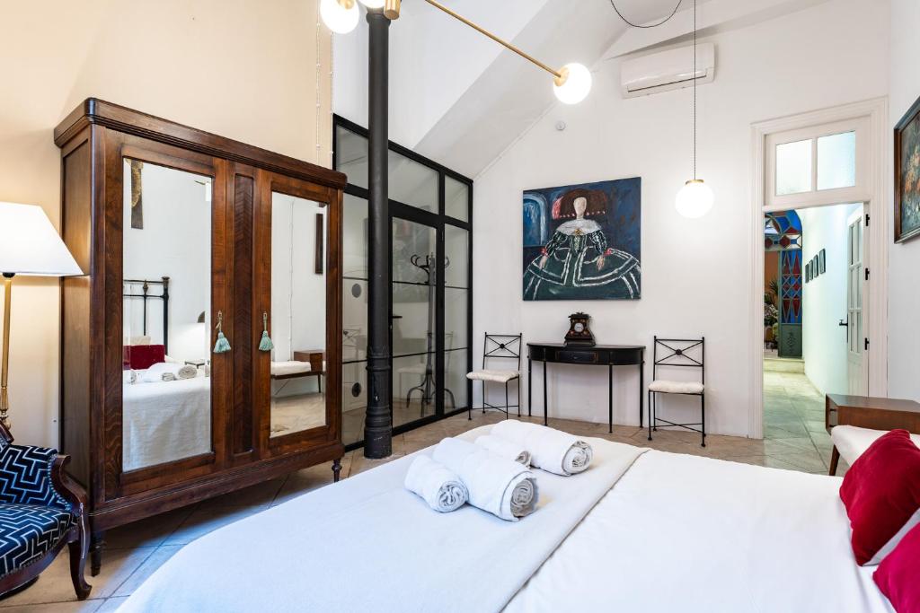sypialnia z dużym białym łóżkiem i biurkiem w obiekcie Teatro Suites Málaga w Maladze