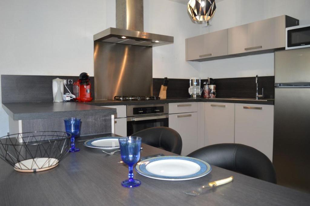 une cuisine avec une table avec des assiettes et des verres dessus dans l'établissement Appartement 3 pièces 6 personnes SC540-A156, à Saint Cyprien Plage