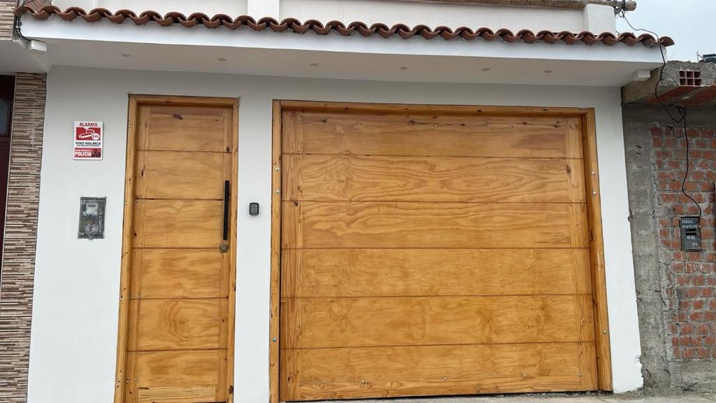 a pair of wooden doors on a house at Casa Apartament Paseo Del Mar in Chimbote