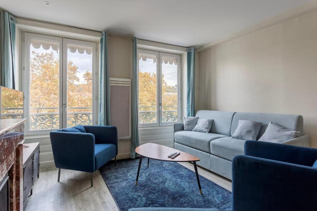 un salon avec un canapé, deux chaises et une table dans l'établissement Hamac Suites - Suite Arloing - 6 people, à Lyon