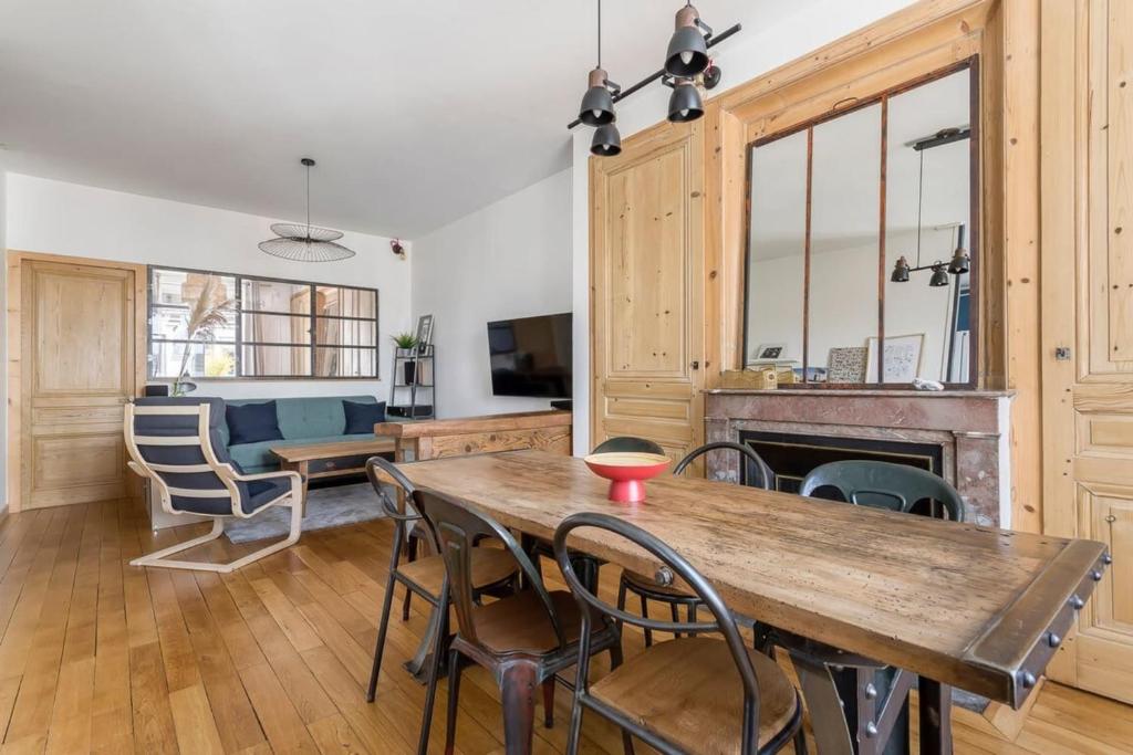 un salon avec une table et des chaises en bois dans l'établissement Hamac Suites - Le Renan - 4 people, à Lyon