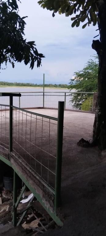 a tennis court behind a fence next to a body of water at Hospedaje Luz d' Luna in Puerto Triunfo