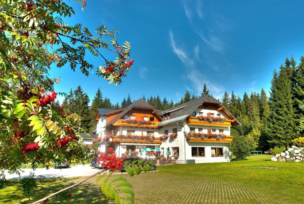 a large building with many windows and a yard at Alpengasthof Fichtenheim in Ramsau am Dachstein