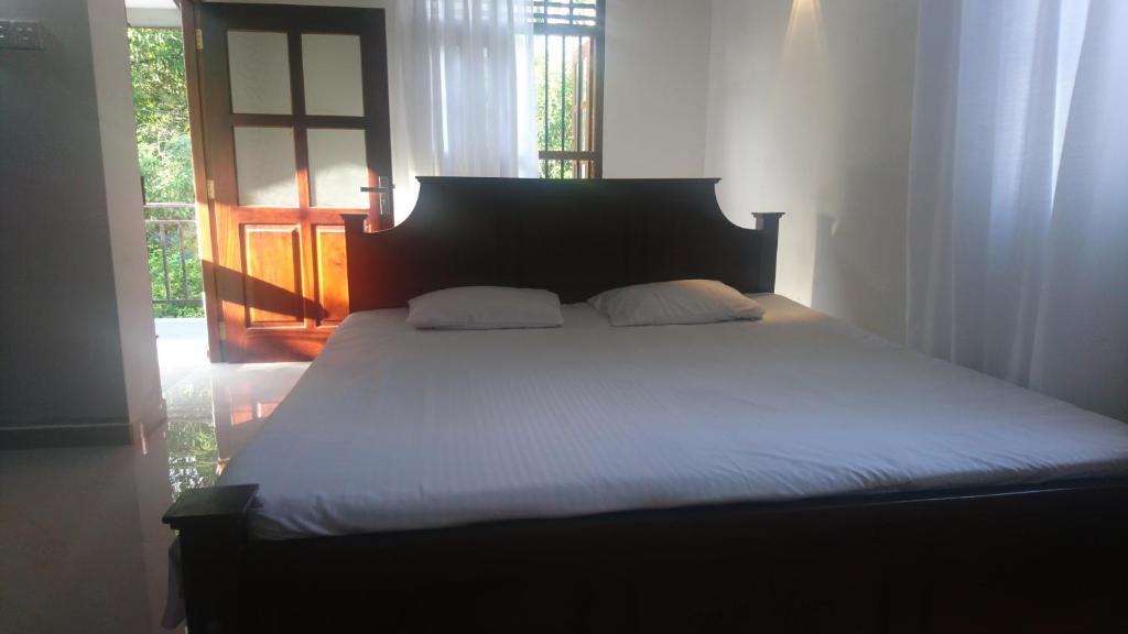 a bed with two pillows in a bedroom at Uma Guest House in Kahawa