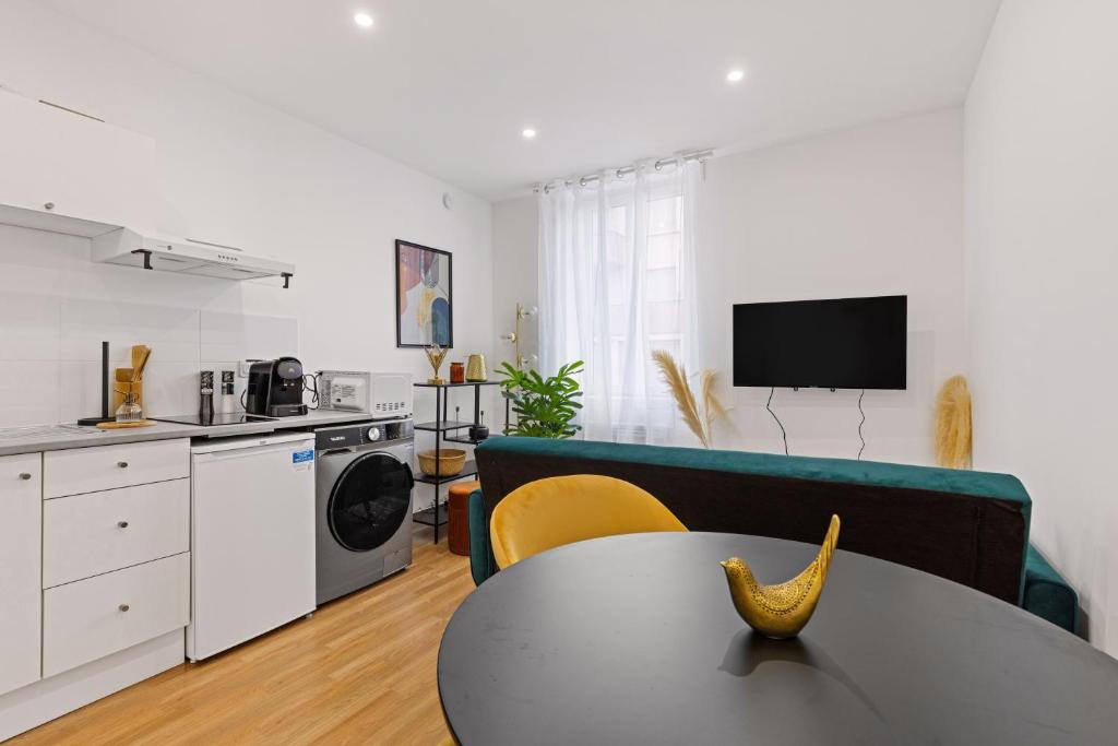 a living room with a table and a kitchen at T2 cosy - stationnement gratuit in Bourg-en-Bresse