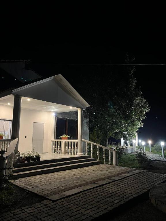 a small white house with a porch at night at MM HOUSE Stepanavan in Stepʼanavan