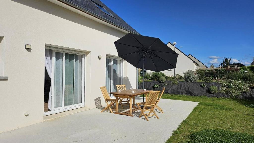 une table et des chaises avec un parasol sur une terrasse dans l'établissement Maison neuve avec jardin, terrasse à PERROS-GUIREC - Réf 918, à Perros-Guirec