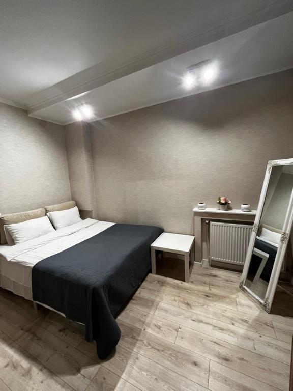 ein Schlafzimmer mit einem großen Bett und einem Tisch in der Unterkunft Квартира в центральній частині Луцька in Luzk