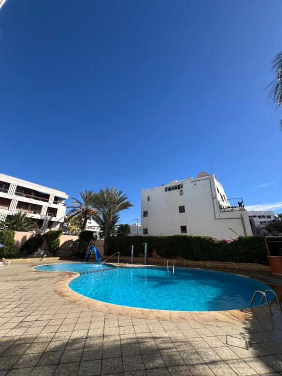 a swimming pool in front of a building at Hôtel Résidence Louban in Agadir