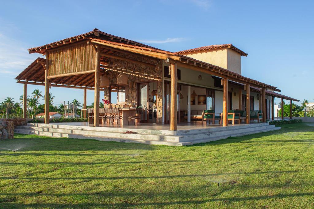 a building with a porch with tables and chairs at Casa Licuri Corumbau in Corumbau