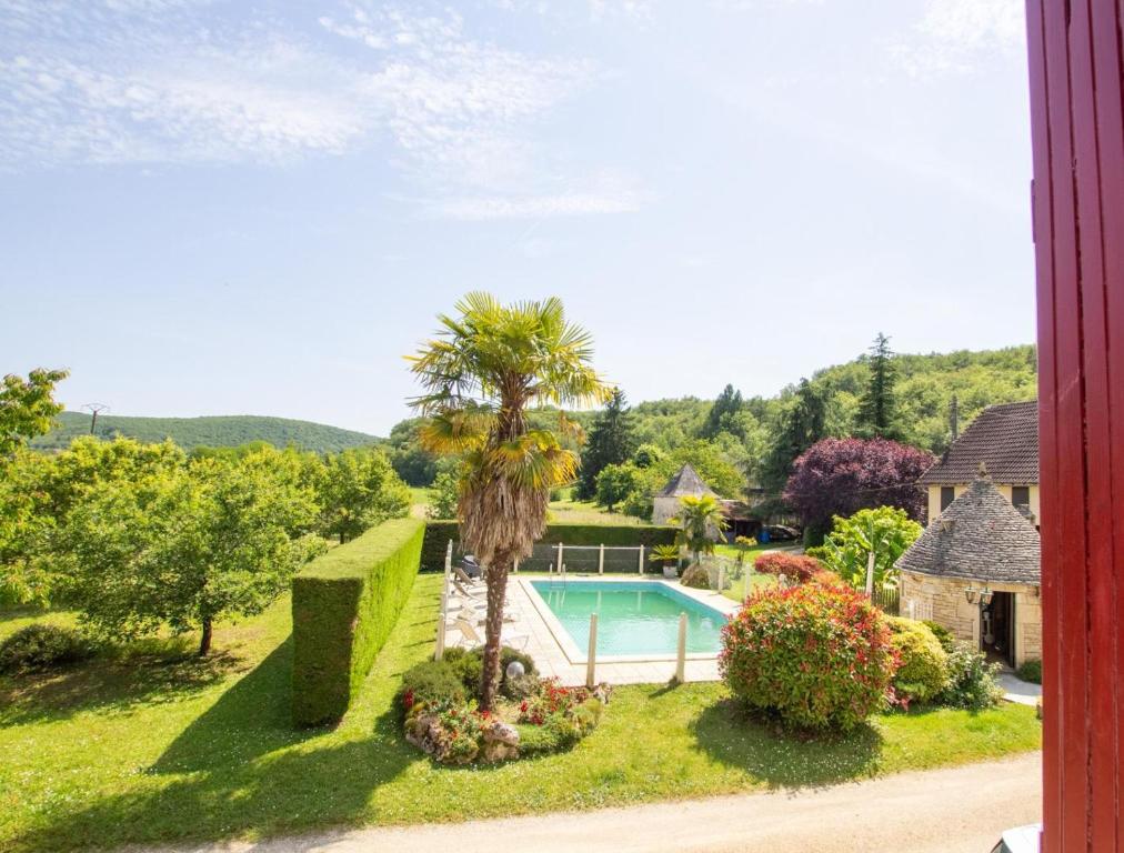 una casa con piscina y una palmera en Les bories, en Condat-sur-Vézère