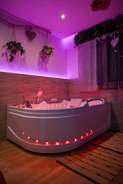 - un bain à remous dans une pièce avec éclairage violet dans l'établissement Love Room Luxe Près de la Mer, à Fréjus