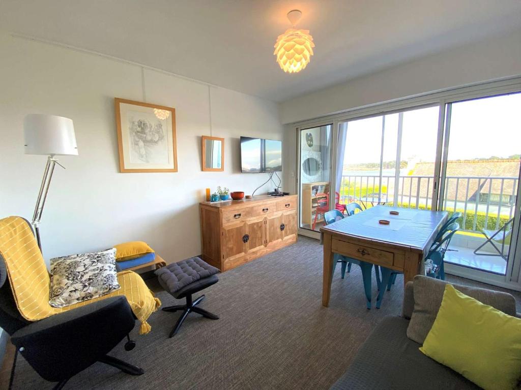 un salon avec une table et des chaises dans l'établissement Appartement VUE MER avec WIFI, loggia, au centre de TREGASTEL - Réf 92, à Trégastel