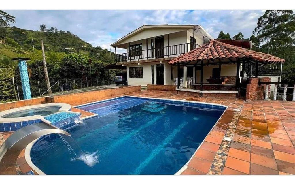a swimming pool in front of a house at Finca la mariana in Pereira