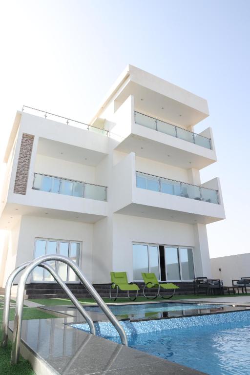 a house with a swimming pool in front of it at شالية ماربيا الاشخرة Marbella Ashkhara Chalet in Al Ashkharah