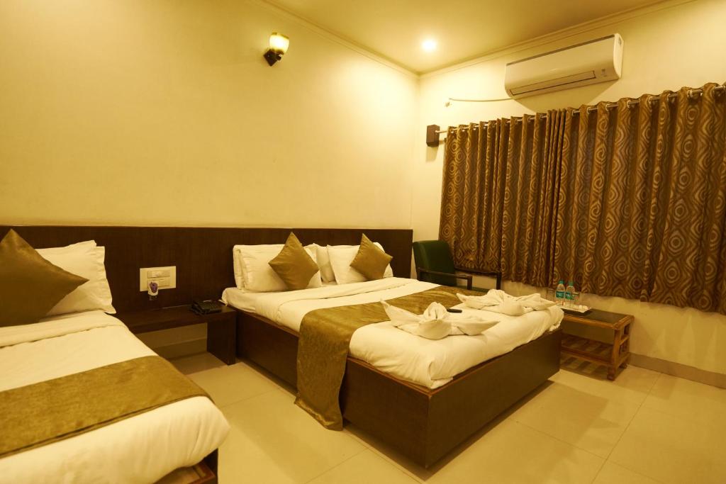 Postel nebo postele na pokoji v ubytování Hotel Pride Inn Shirdi