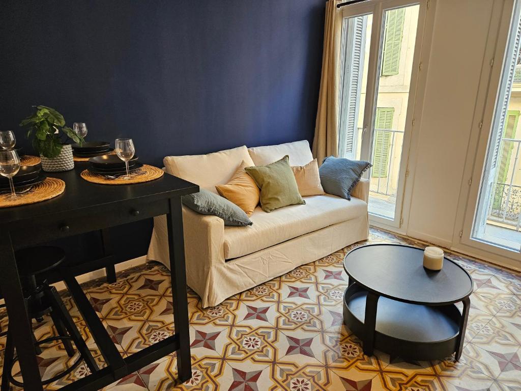 un salon avec un canapé et une table dans l'établissement Évasion bleue, balcon ensoleillé, à Nîmes