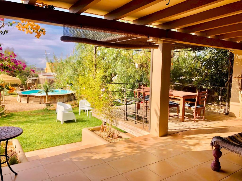 d'une terrasse avec vue sur un jardin doté d'une table et de chaises. dans l'établissement Villa Es Repaire near to Playa Den Bossa, à Ibiza