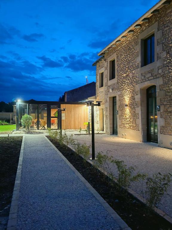 un bâtiment en pierre avec un chemin devant lui dans l'établissement Domaine du Vieux Porche, à Mignaloux-Beauvoir